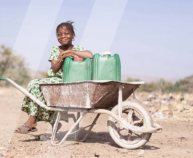 Young African girl in wheelbarrow
